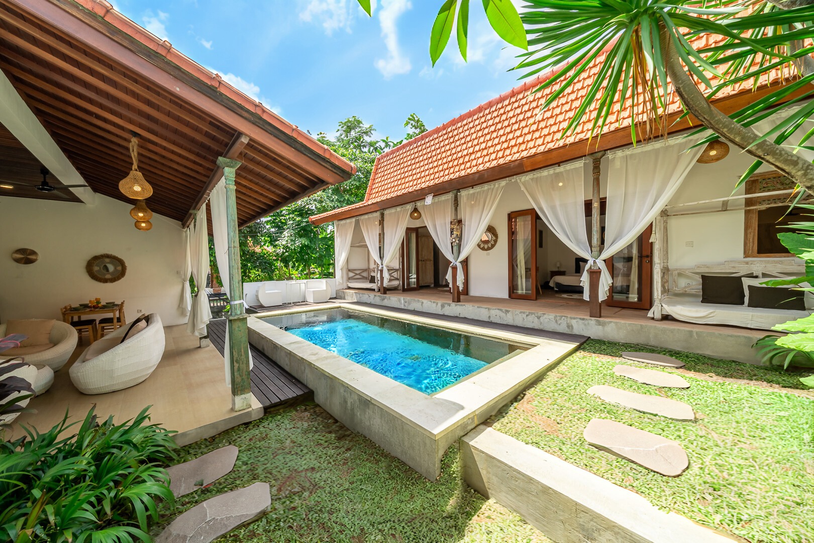 Villa River Side in Canggu, Bali: swimming pool in a tropical courtyard with tiled-roof pavilions.